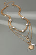 MULTI PEARL LAYER PEARL SUN CROSS CHARM NECKLACE | 80N92503