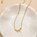 MINI GOLD BOW CHARM NECKLACE | 80N346